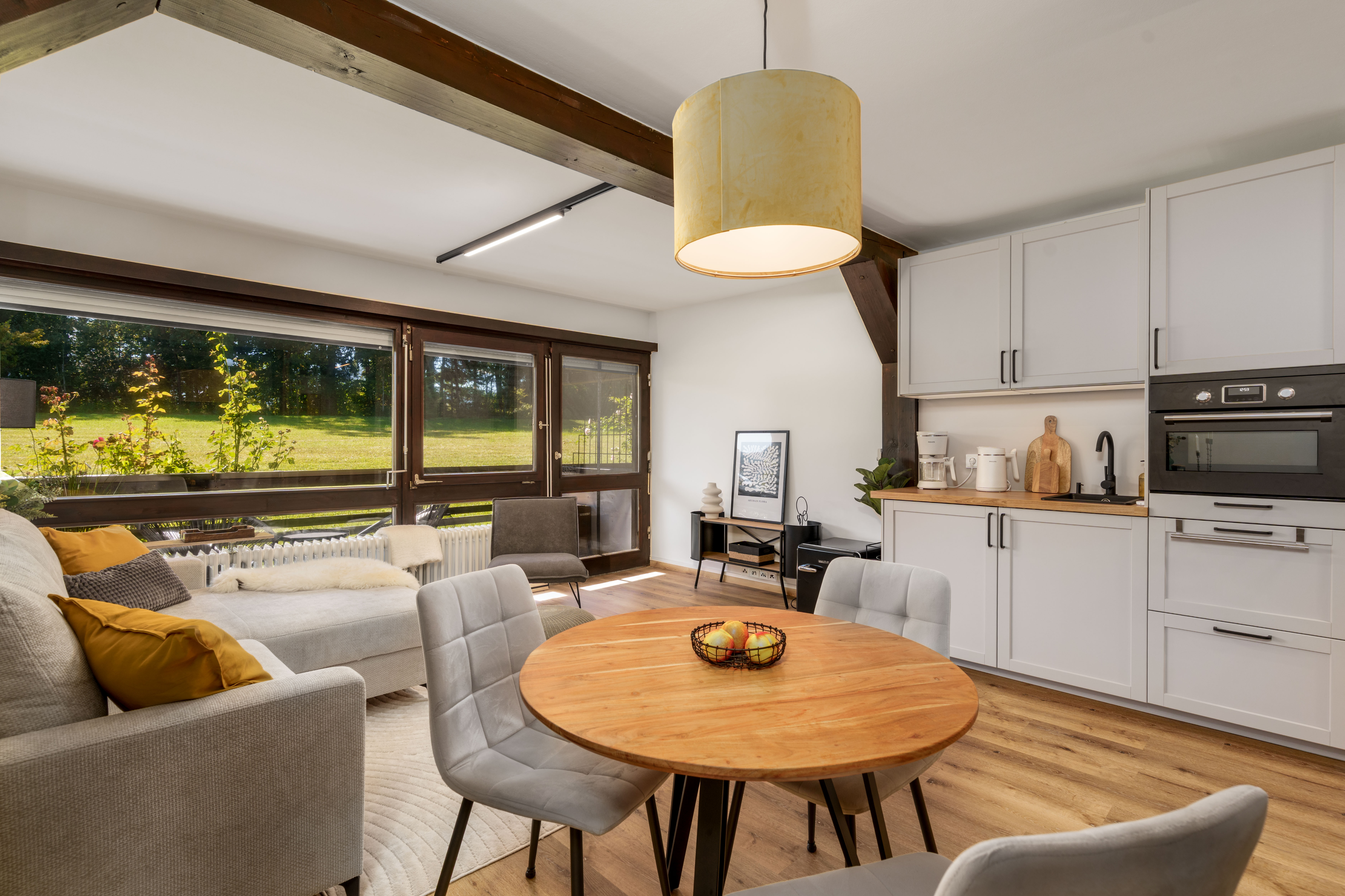 Wohnraum der Ferienwohnung Enzian mit Holzbalken und modernen Akzenten